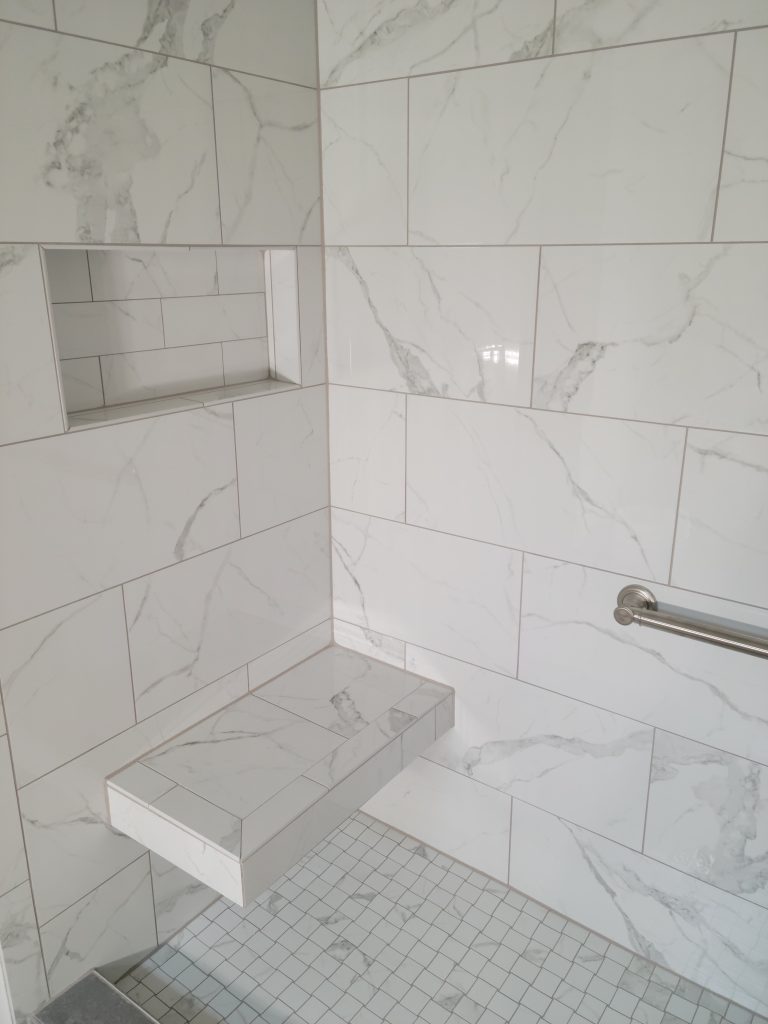 Better Bench shower seat with tile walls and niche.